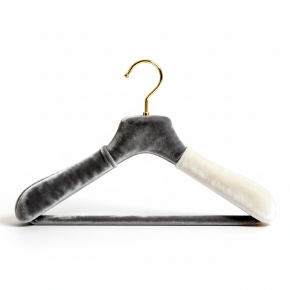 Dual-tone velvet clothes hanger with sculpted shoulders and gold curved hook on a white background