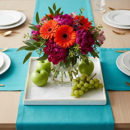 White marble-effect gold-rim tray styled as a colorful dining table centerpiece with flowers and fruit