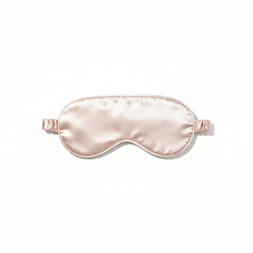Blush-pink satin sleep mask with a softly padded curved shape on a white background